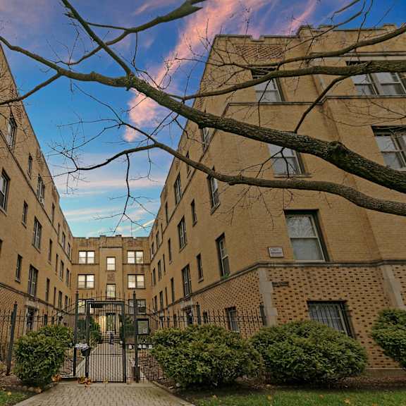 a courtyard between two brick buildings with a blue sky