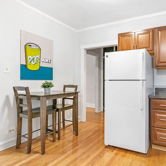 a kitchen with wooden cabinets and a table and a refrigerator