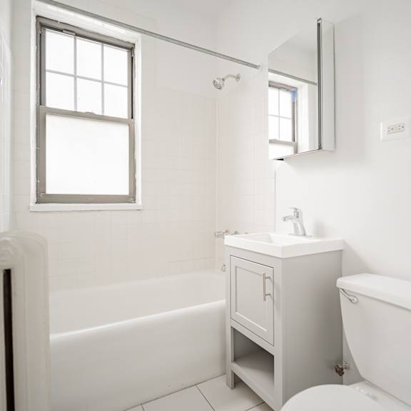 a white bathroom with a tub and a sink