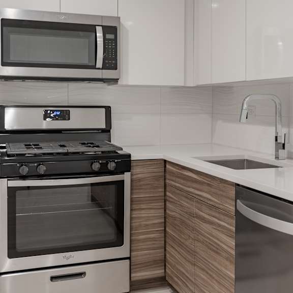 a modern kitchen with a stainless steel dishwasher and microwave above the stove.