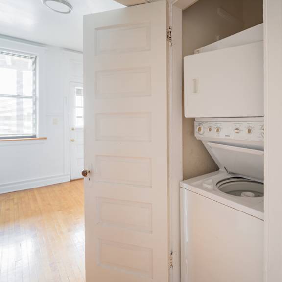 a small kitchen with a white stove and refrigerator and a white door