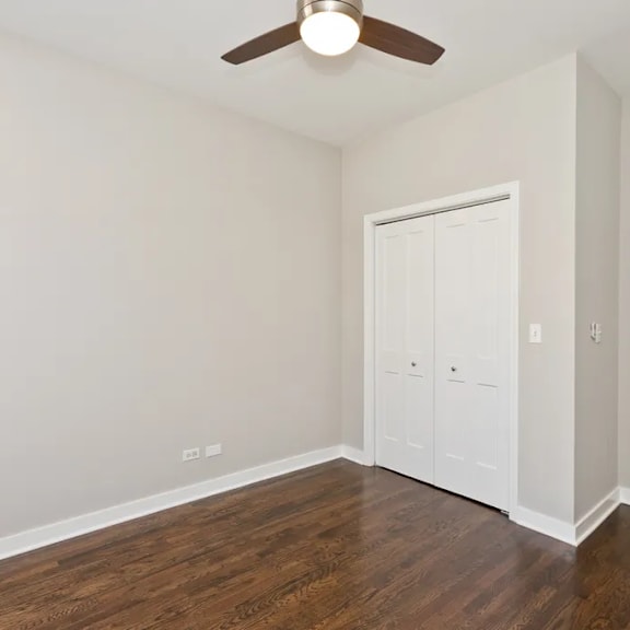 a room with a ceiling fan and wood flooring.