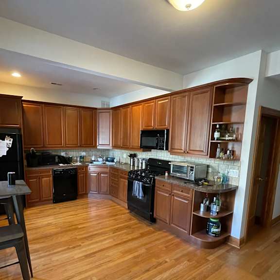 a kitchen with wooden cabinets and black appliances.