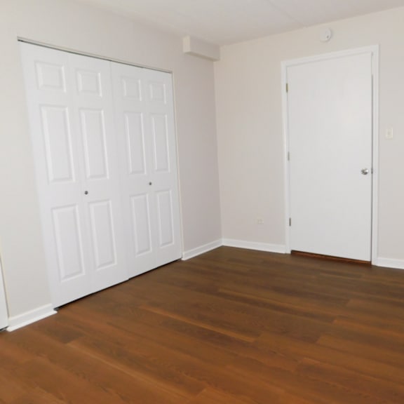 a room with a white door and a brown floor.