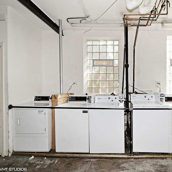 an old laundry room with white appliances and two windows
