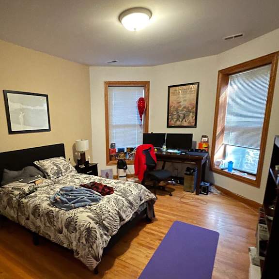 a bedroom with a bed, desk, and chair.