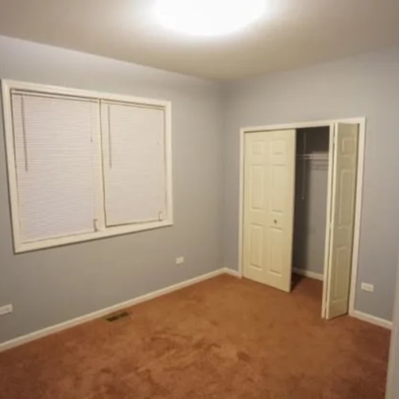 a empty room with a window and a closet