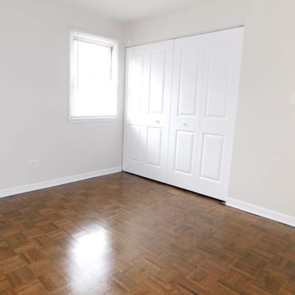 a room with a wooden floor and a white door.