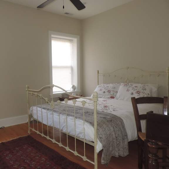 a bedroom with a bed and two windows