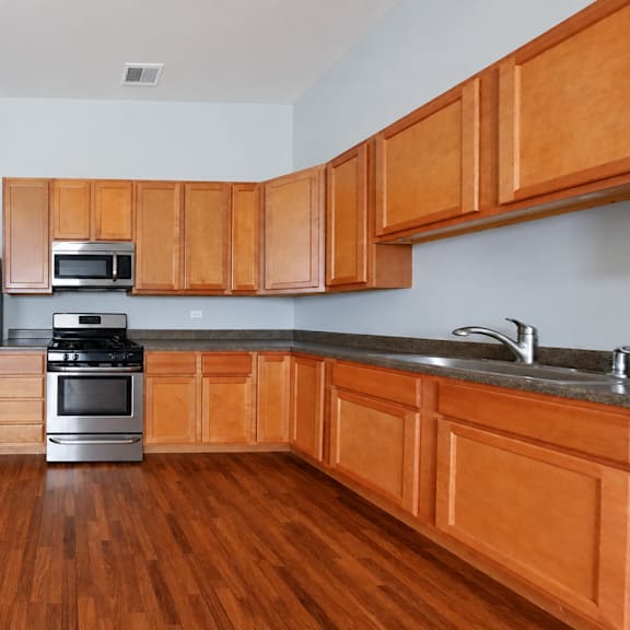a kitchen with wooden cabinets and a stainless steel refrigerator.