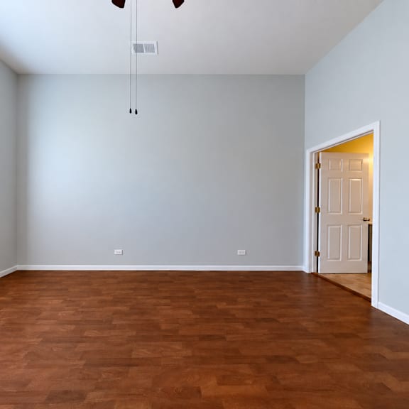 a room with a brown floor and white walls.