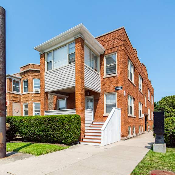 a red brick house with a white door and windows.