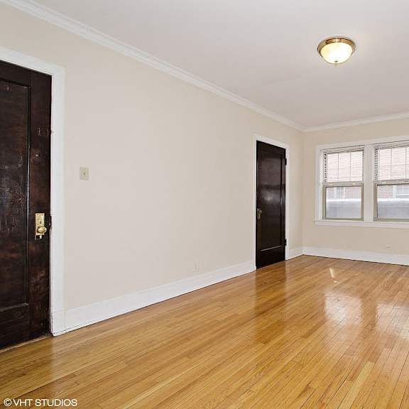an empty living room with wood floors and a black door