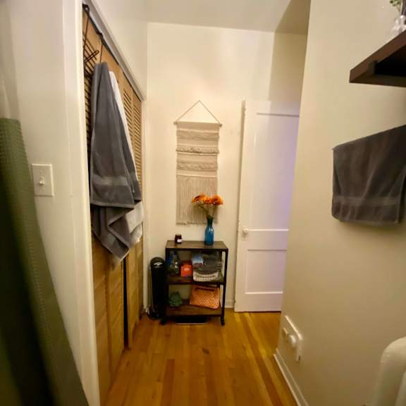 a hallway with a coat rack and a small table with flowers on it.