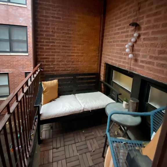 a small balcony with a bench and a table.