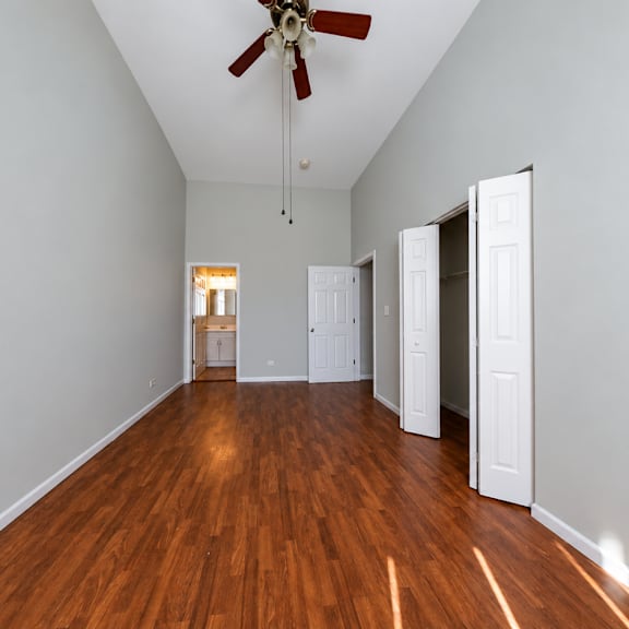 a room with a ceiling fan and wooden flooring.