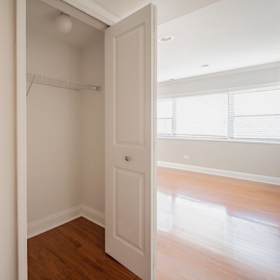 a white door is open to a room with a light switch on the wall.