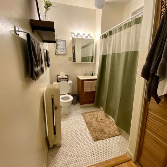 a bathroom with a toilet, sink, and a mirror.