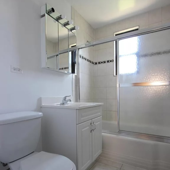 a white toilet sits next to a sink in a bathroom.