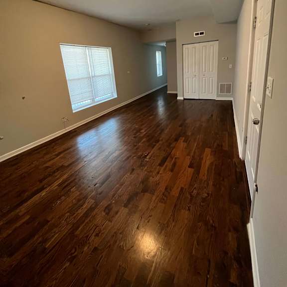 a living room with a hard wood floor and a white door