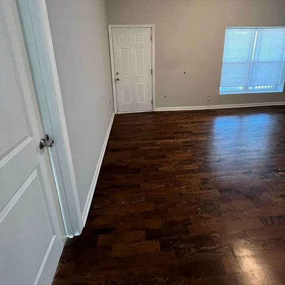 a living room with wooden floors and a white door