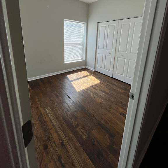 an empty room with wooden floors and white walls