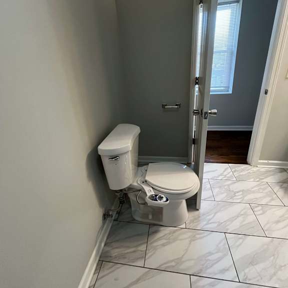 a bathroom with a toilet and an open door