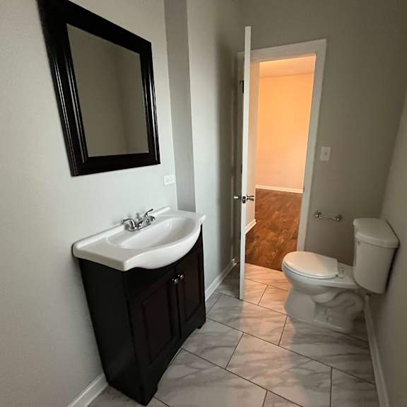a bathroom with a sink toilet and a mirror
