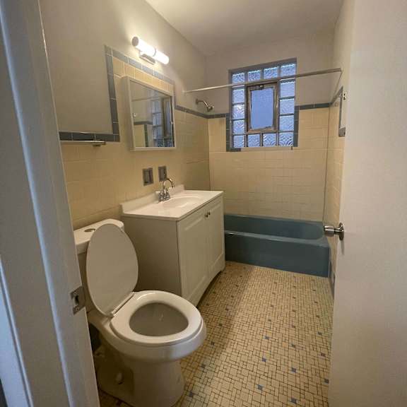 a bathroom with a toilet, sink, and bathtub.