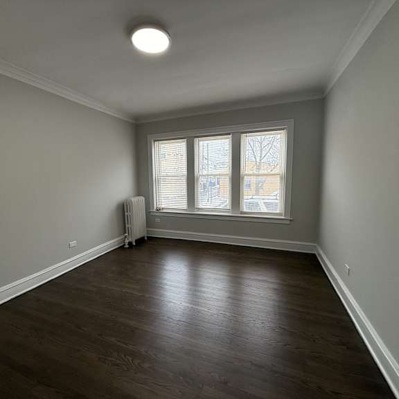 a room with a window and a radiator on the floor.