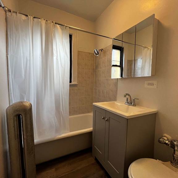 a bathroom with a white sink, a toilet, a bathtub, and a mirror.