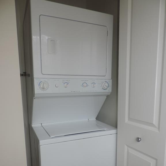 a white washer and dryer in a white closet