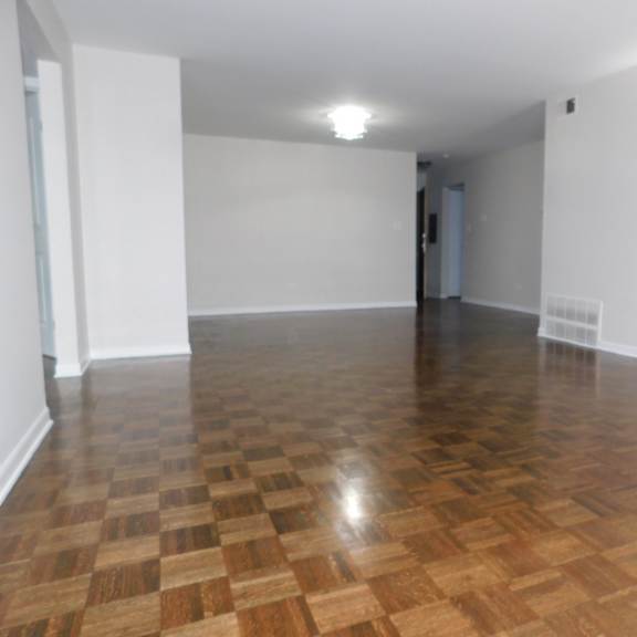 a room with wooden flooring and white walls.
