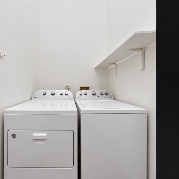 a white washing machine and dryer in a small room.