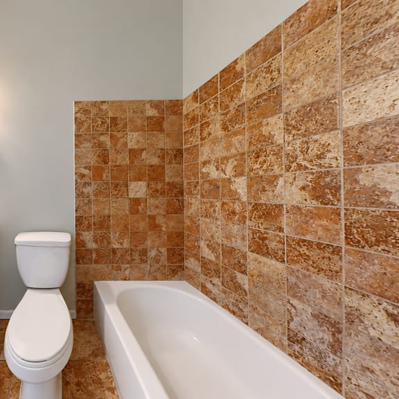a bathroom with a white toilet, sink, and bathtub.