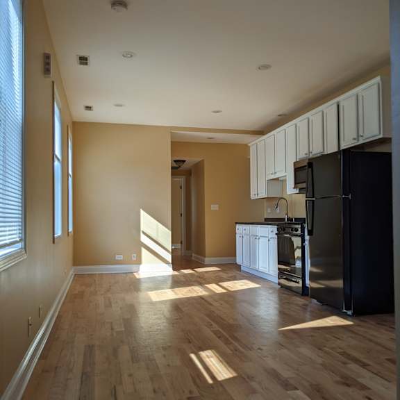 a kitchen with wooden floors and white cabinets.