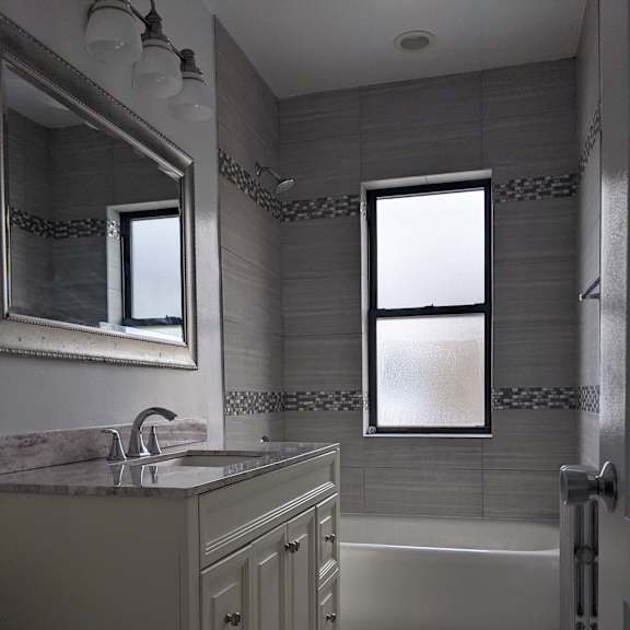 a bathroom with a marble countertop and a large mirror.
