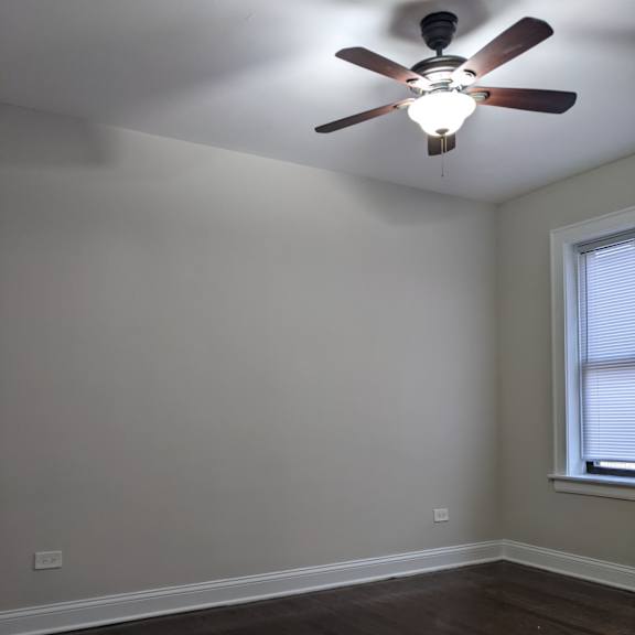 a room with a ceiling fan and a window.