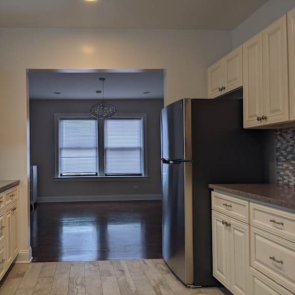 a kitchen with a black refrigerator and white cabinets.