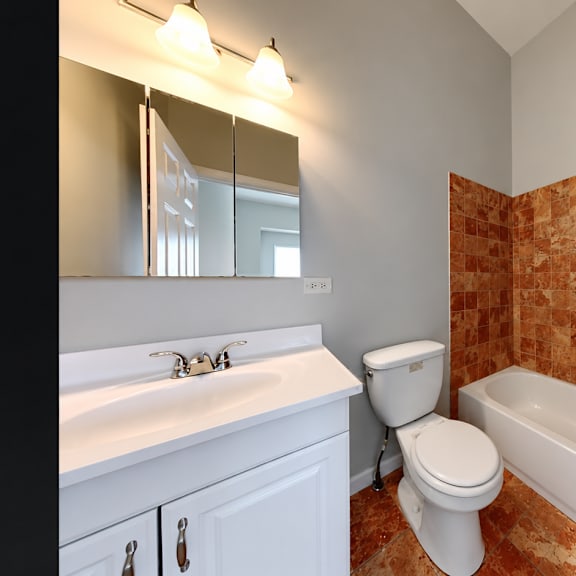 a bathroom with a toilet, sink, and bathtub.