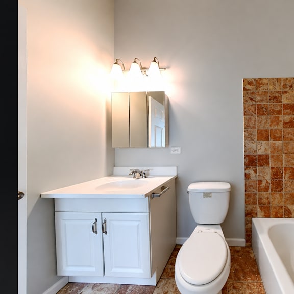 a bathroom with a toilet, sink, and tub.