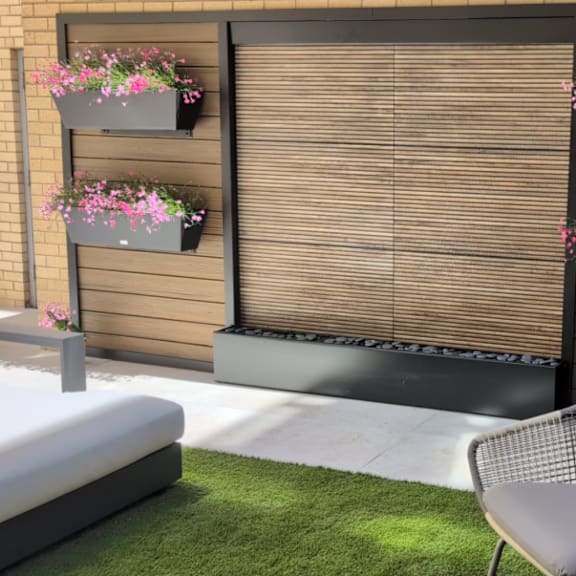 a patio with a chair, a bench, and flower pots.