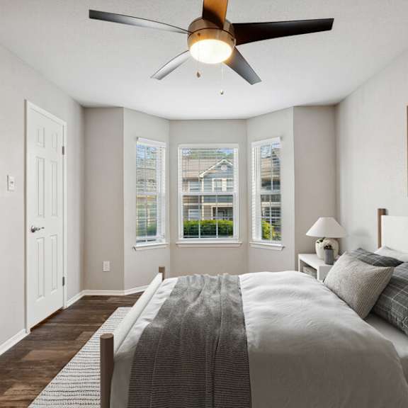 a bedroom with a large bed and a ceiling fan