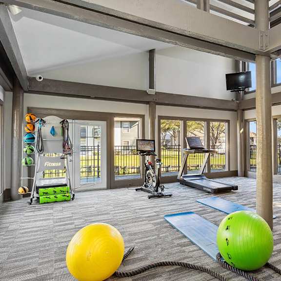 community fitness center with equipment at seven lakes at carrollwood apartments in tampa, fl.