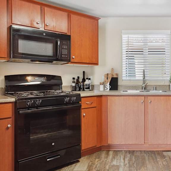 model kitchen with black appliances at reserve at rancho apartments