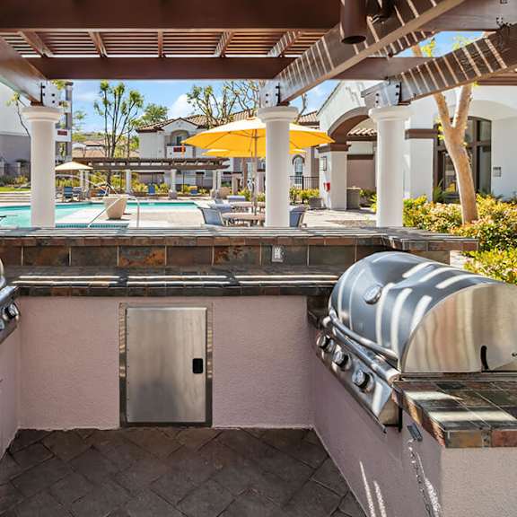 outdoor bbq area with canopy & view of pool at reserve at rancho apartments located in moreno valley, ca.