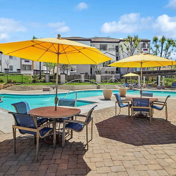 community swimming pool with pool furniture at reserve at rancho apartments located in moreno valley, ca.