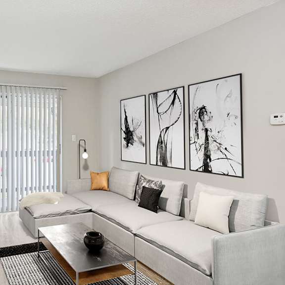 model living room with wood-style flooring and patio accessibility at seven lakes at carrollwood apartments in tampa, fl.