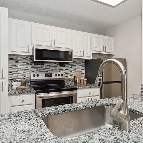 model kitchen with white cabinets at seven lakes at carrollwood apartments in tampa, fl.