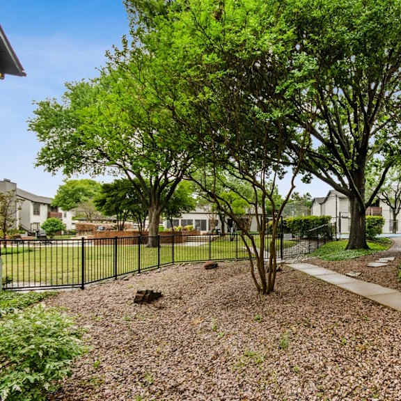 apartment courtyard with trees and a fence
